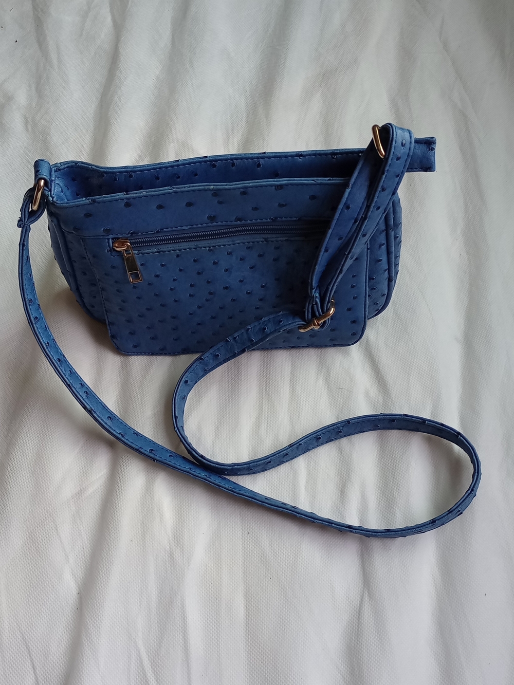 blue faux-ostrich leather crossbody bag with an adjustable strap